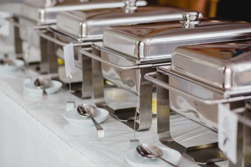 A row of silver trays with spoons on them.